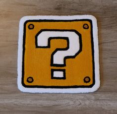 a yellow and black question sign on top of a wooden table