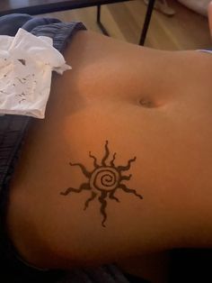 a woman with a sun tattoo on her stomach