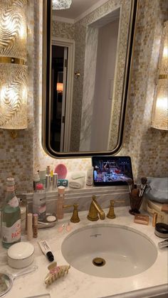 a bathroom vanity with a mirror and various items on it