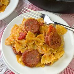 a plate with pasta and sausage on it