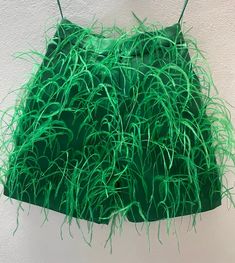 green grass hanging from the ceiling in front of a white wall