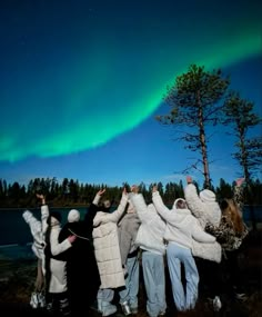 group of people standing in front of an aurora bore