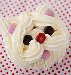 a cupcake decorated with white frosting and chocolate candies