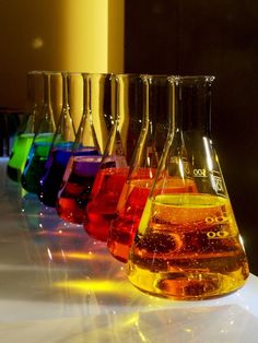 a row of flasks filled with different colored liquids