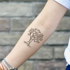 a woman's arm with a tree tattoo on it