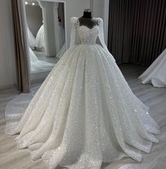 a wedding dress on display in front of a mirror