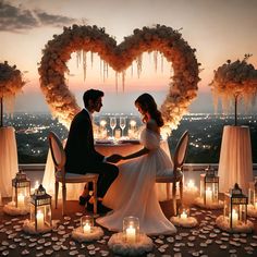 a man and woman sitting at a table with candles in the shape of a heart