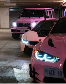 pink cars parked in a parking garage with their lights on and the hoods down