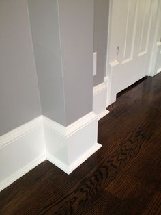 an empty room with wood floors and white trim on the walls, along with wooden flooring