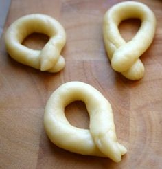 four pretzels are sitting on a cutting board