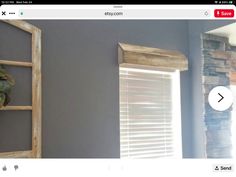 an image of a window with shutters on the side and a brick fireplace in the background