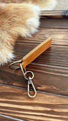 an animal's tail is attached to a leather keychain