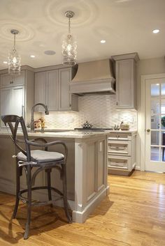 a large kitchen with an island and bar stools