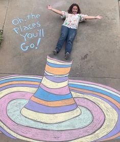 a woman laying on the ground with her arms outstretched in front of a colorful cone