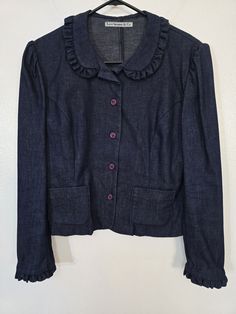 "Cowgirl up! In, of course, this Vintage 1980s Levi Strauss & Co. dark blue lightweight denim ruffle trim blouse jacket! Measured women's bust 36\" Ruffle trim collar and cuffs, small front functional pockets. Peter Pan collar. Paper tag code might be 1982! I've never seen one like this. It looks and feels new and unworn. So if you need a top to match your high waist colored jeans.. hint hint... :) Please see our other listings for more vintage Levi Strauss garments with new items added nearly daily. PLEASE check the measurements as vintage clothing sizes may not comparable to contemporary sizes. Measurements: Label size: vintage 11 Shoulder-to-shoulder: 16\" Chest across: 18\" Sleeve from shoulder: 24\" Length in back from base of collar: 21\" Pete's Obsolete is smoke-free. We present gar Fitted Collared Denim Jacket, Vintage Dark Wash Tops For Work, Retro Fitted Denim Jacket For Workwear, Dark Wash Vintage Tops For Work, Vintage Dark Wash Tops For Fall, Vintage Collared Top In Dark Wash, Fitted Vintage Dark Wash Tops, Vintage Collared Dark Wash Top, Vintage Long Sleeve Dark Wash Tops