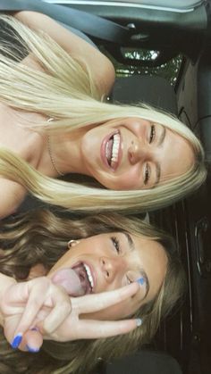 two beautiful young women sitting next to each other in the back seat of a car