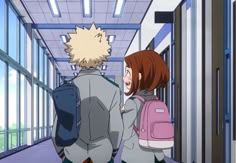 two people standing in an empty hallway with backpacks on their backs and one person looking at the wall