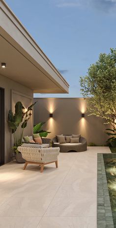 an outdoor living area with couches and lights on the wall, next to a swimming pool