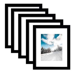 four black frames with a snowy landscape in the middle and trees on the other side