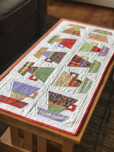 a quilted table runner on top of a wooden coffee table