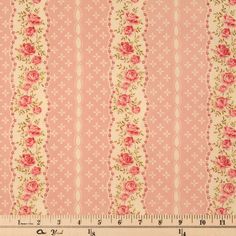 a pink and white striped fabric with roses on the side, next to a ruler