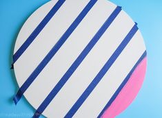 a paper plate with blue and pink stripes on it, sitting on a blue surface