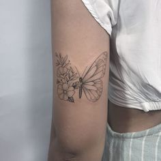 a woman's arm with a butterfly and flowers tattoo on the left upper arm