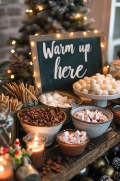 a table topped with bowls filled with marshmallows next to a christmas tree