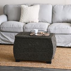 a coffee table sitting on top of a rug in front of a couch with pillows