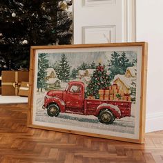 an old red truck with a christmas tree in the back is sitting on a wooden floor