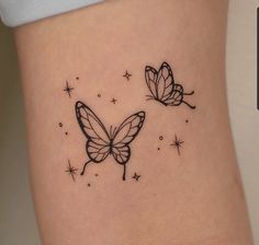 two butterfly tattoos on the side of a woman's stomach, with stars in the background