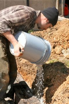 a man is pouring water into a hole