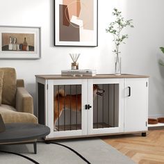 a dog in a kennel is sitting on the floor next to a couch and chair