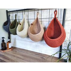 four baskets hanging on a wall in different colors