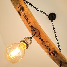 a light that is sitting on top of a wooden pole with chains hanging from it