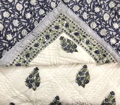 three pieces of blue and white quilted material on top of each other with leaves