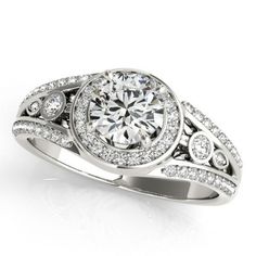 a white gold ring with diamonds on the sides and a center stone in the middle