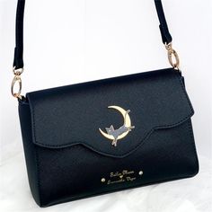 a black purse with a bird on the front and a crescent moon on the back