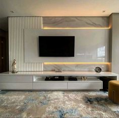 a modern living room with white furniture and a flat screen tv mounted on the wall