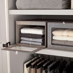 an organized closet with folded towels and folded linens in bins on the shelves