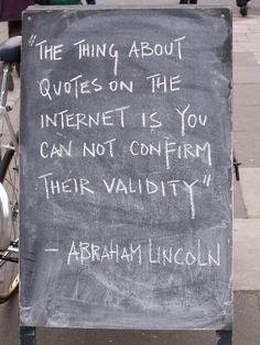 a chalkboard with writing on it sitting next to a bike parked in front of a building