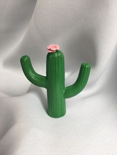 a green cactus with a pink flower on it