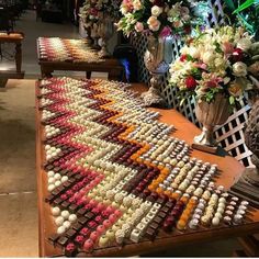 several vases with flowers and candles on display at a wedding reception in the lobby