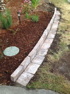 a garden bed with mulch and flowers in it