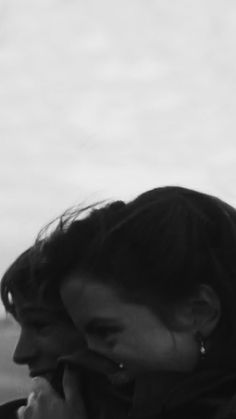 black and white photograph of a woman talking on her cell phone in front of the ocean