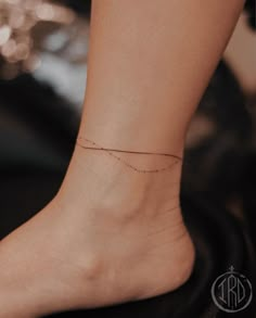 a woman's foot with a tiny line tattoo on the side of her ankle