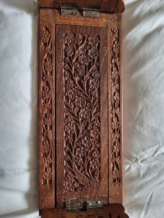 an intricately carved wooden box on a white sheet