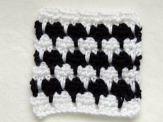 the crochet is black and white with hearts on it's center piece