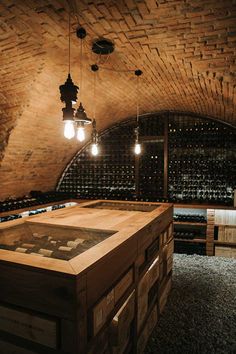 a wine cellar filled with lots of bottles and light bulbs hanging from the ceiling above it