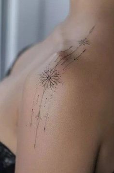 a woman's chest with a dandelion tattoo on it